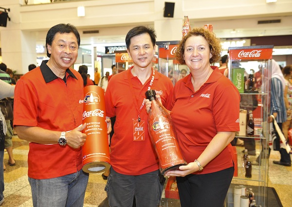 Pengurus Besar Coca-Cola untuk Singapore-Malaysia-Brunei, Gill McLaren (paling kanan), dan Pengarah Hal Ehwal Awam dan Komunikasi Coca-Cola, Kadri Taib (paling kiri), bertemu dengan salah satu kolektor di ruang pameran