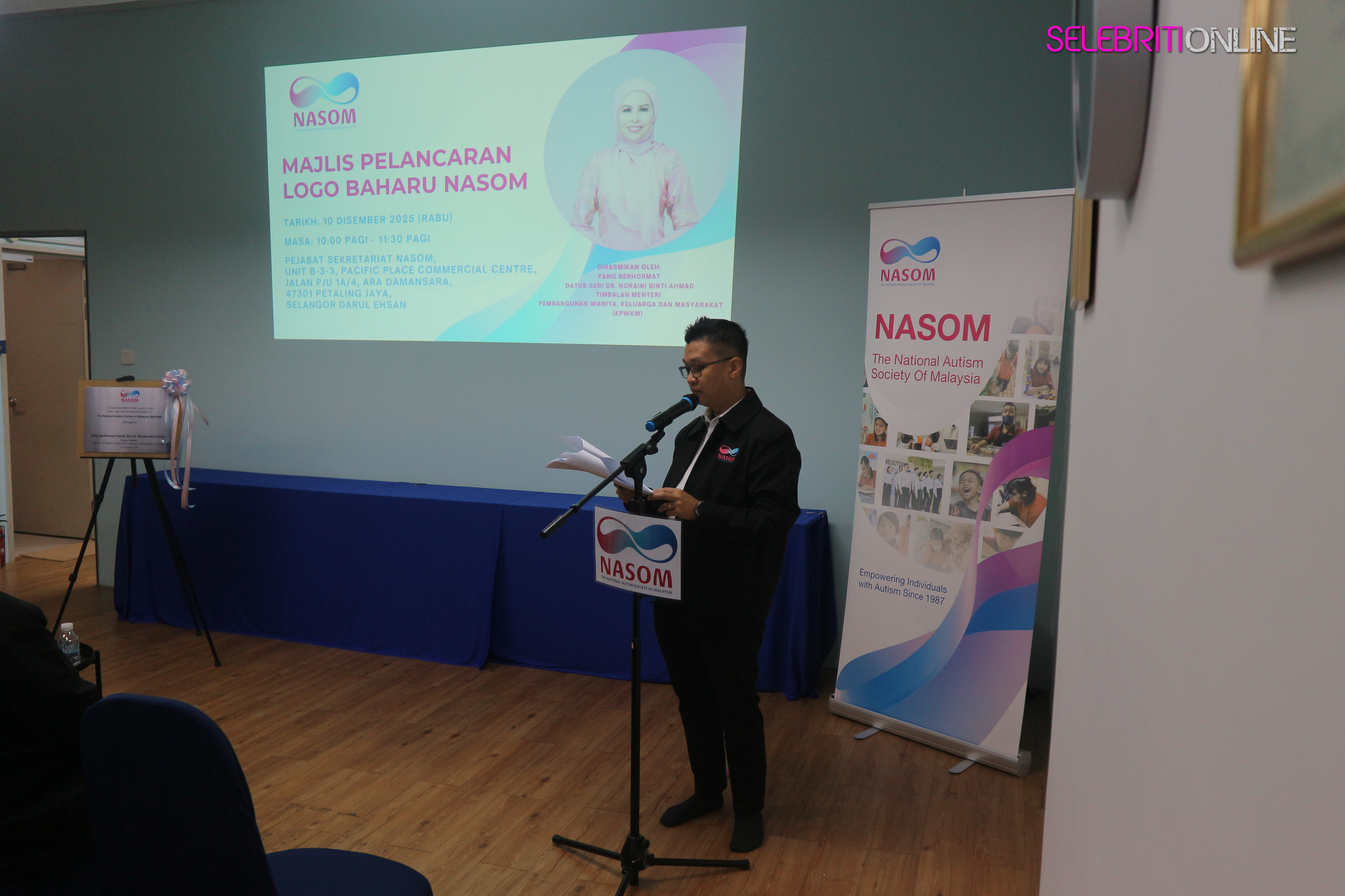 Logo Baharu NASOM dengan simbol infiniti dalam warna merah jambu, firus dan biru.